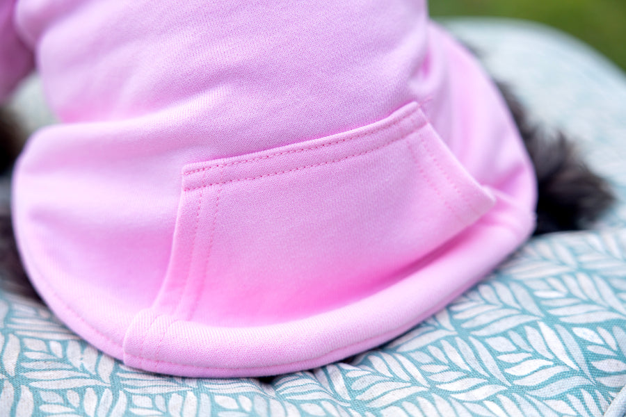 Close up of large pocket of dog shirt in pink.