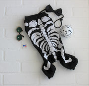 Cute dog costume with skeleton, black and white, flat lay with dog accessories.